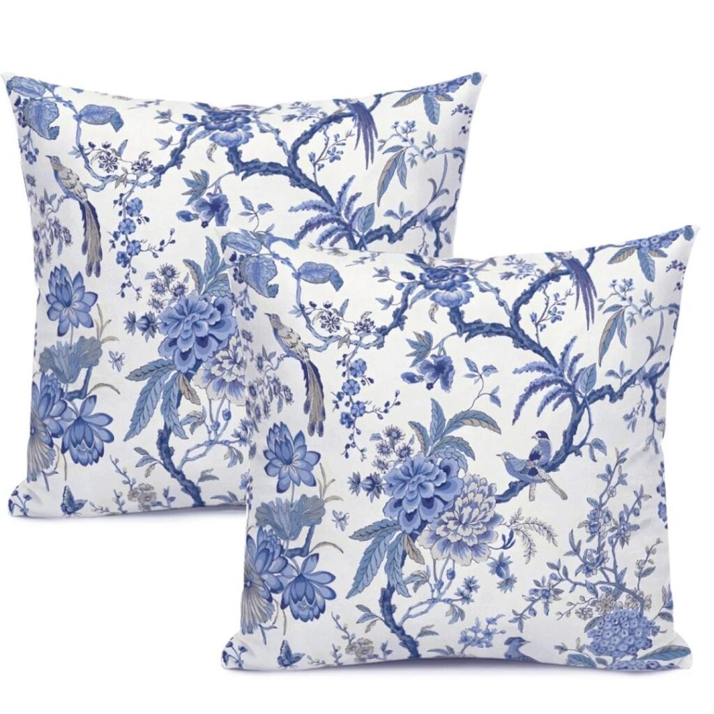 Elegant blue and white throw pillows on a white couch with coastal decor accents