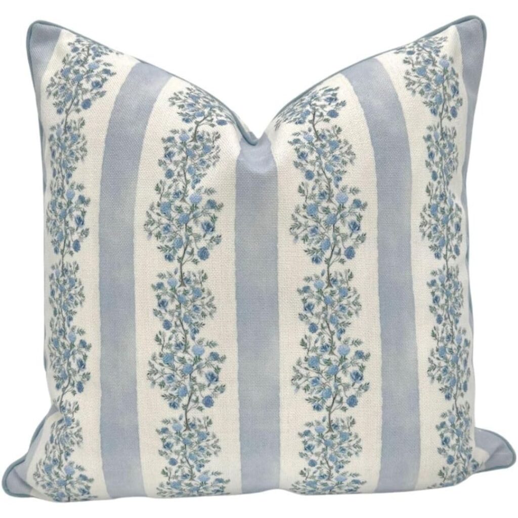 Blue and white decorative throw pillows on a neutral sofa in a cozy living room